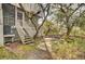 Steps leading to a screened porch and patio, surrounded by lush landscaping and trees at 1077 Marsh Court Ln, Mount Pleasant, SC 29464