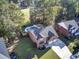 Aerial view of a two-story brick home with a pool, situated on a tree-lined street at 111 Dasharon Ln, Goose Creek, SC 29445