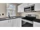 Modern kitchen with white cabinets, stainless steel appliances, and dark countertops at 1243 Pineville Cir, Pineville, SC 29468
