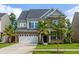 Two-story brick home with gray roof, palm trees, and a large driveway at 192 Lindera Preserve Blvd, Summerville, SC 29486