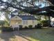 Cute yellow cottage with front porch, under large shade tree at 29 Riverdale Dr, Charleston, SC 29407