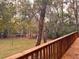 Wooden deck with railing and view of a grassy backyard and trees at 6464 St Anthony Dr, Hollywood, SC 29449