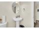 Small bathroom with pedestal sink, oval mirror, and a view into another room at 223 Laurel Crest Way, Summerville, SC 29486