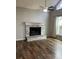 Living room with a whitewashed brick fireplace and wood-look floors at 114 Lewisfield Dr, North Charleston, SC 29418