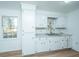 White kitchen with ample cabinet space and laminate floors at 110 Edgebrook Dr # 28, Summerville, SC 29486