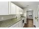 Kitchen with white cabinets, green countertops, and a view into dining area at 1370 Pinnacle Rd, Charleston, SC 29412