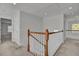 Upstairs hallway with neutral carpeting, wood and white railings, and doors to bedrooms at 1565 Ashley Garden Blvd, Charleston, SC 29414