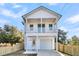 Two-story white farmhouse with a front porch, attached garage, and fenced yard at 2015 Groveland Ave, North Charleston, SC 29405