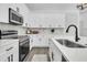 Modern white kitchen with stainless steel appliances and quartz countertops at 2015 Groveland Ave, North Charleston, SC 29405