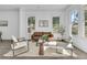 Bright living room with a brown leather sofa, two armchairs, and large windows at 2015 Groveland Ave, North Charleston, SC 29405