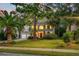 Evening view of two-story house with gray siding, red door, and lush landscaping at 2778 Seastrand Ln, Mount Pleasant, SC 29466