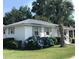 Charming white brick ranch home with gray shutters, lush landscaping, and a metal roof at 509 Live Oak Dr, Mount Pleasant, SC 29464