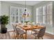 Bright dining room with wood table, gray chairs, and large windows at 534 Four Seasons Blvd, Summerville, SC 29486