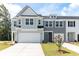 Two-story townhome with gray siding, white garage doors, and landscaping at 569 Trotters Ln # 222, Moncks Corner, SC 29461