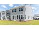 Townhouse exterior showcasing grey siding and grassy backyard at 569 Trotters Ln # 222, Moncks Corner, SC 29461