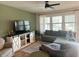 Bright living room with sectional sofa, large TV, and stylish farmhouse-style media console at 1011 Mossy Rock Dr, Summerville, SC 29485