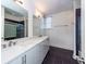 Modern bathroom with double vanity, quartz countertop, and dark tile floors at 195 Saint Philip St, Charleston, SC 29403