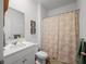 Clean bathroom with white vanity, shower/tub combo, and beige shower curtain at 671 Silver Spruce St, Summerville, SC 29486