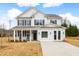 Two-story farmhouse-style home with white siding, dark shutters, and a front porch at 780 Maynard Ln, Summerville, SC 29486