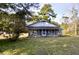 Ranch style home with blue accents and screened porch, nestled in a wooded lot at 8146 N Highway 17, McClellanville, SC 29458