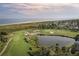 Aerial view of a golf course with ocean and houses in the background at 102 High Hammock Villas, Seabrook Island, SC 29455