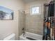 Bathroom with tiled shower/tub combination and a unique mermaid window at 108 Palmetto Blvd, Edisto Beach, SC 29438