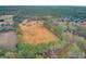 Aerial view showing the home and large lot, surrounded by trees and fields at 388 E Main St, Harleyville, SC 29448