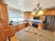 Modern kitchen with granite island, wood cabinets, and stainless steel appliances at 388 E Main St, Harleyville, SC 29448