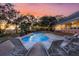 Kidney shaped pool with lounge chairs and sunset view at 122 Cainhoy Landing Rd, Charleston, SC 29492