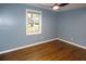 Simple bedroom with hardwood floors and light blue walls at 1278 S Lenevar Dr, Charleston, SC 29407