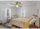 Simple bedroom with a colorful quilt, white walls, and two windows with curtains at 2305 Myrtle St, Edisto Beach, SC 29438
