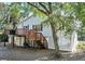 View of a two-story home with a deck, stairs, and surrounding trees at 2305 Myrtle St, Edisto Beach, SC 29438