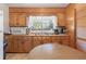 Compact kitchen with ample wood cabinetry, a double sink, and a small dining table at 2305 Myrtle St, Edisto Beach, SC 29438