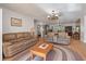 Open living room with leather furniture, unique chandelier, and views of a sunroom at 2305 Myrtle St, Edisto Beach, SC 29438