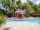 Relaxing pool area with gazebo, lounge chairs, and red umbrellas at 45 Sycamore Ave # 1323, Charleston, SC 29407