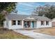 Newly renovated white brick ranch house with gray roof and a teal front door at 4571 Garwood Dr, Ladson, SC 29456