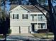 Two-story light green house with black shutters, two-car garage, and a front porch at 104 Elliott Creek Ln, Summerville, SC 29485