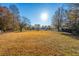 Large backyard with dry grass and a wooden fence at 7011 Windmill Creek Rd, Charleston, SC 29414