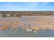 Aerial view of waterfront property with a long pier leading to a covered structure at 9681 Two Pines Rd, McClellanville, SC 29458