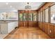 Dining area with wood paneled walls, hardwood floors, and large windows at 9681 Two Pines Rd, McClellanville, SC 29458