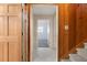 Hallway with wood paneling, tile floor and doors to bedrooms and stairs at 9681 Two Pines Rd, McClellanville, SC 29458