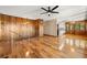 Open living room with hardwood floors, wood paneled walls, and view into kitchen area at 9681 Two Pines Rd, McClellanville, SC 29458