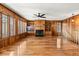 Living room with wood paneling, hardwood floors, and a cozy fireplace at 9681 Two Pines Rd, McClellanville, SC 29458