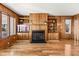 Living room with wood paneled walls, hardwood floors, built-in shelving, and fireplace at 9681 Two Pines Rd, McClellanville, SC 29458