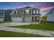 Two-story home with gray brick and siding, three-car garage, and landscaped yard at 117 Crosscut Ln, Summerville, SC 29486