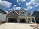 Two-story home with gray siding, brick accents, and a three-car garage at 117 Crosscut Ln, Summerville, SC 29486
