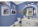 Blue bathroom with white vanity, round mirror, and nautical decor at 2054 Briar Bend Rd, Ridgeville, SC 29472