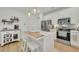 White kitchen with center island, stainless steel appliances, and light wood floors at 432 Eva St, Moncks Corner, SC 29461