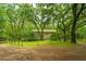 Fenced backyard with a grassy area and mature trees at 8389 Chisolm Plantation Rd, Edisto Island, SC 29438