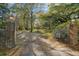 Gated driveway leading to a secluded home surrounded by lush trees at 9875 Jamison Rd, Summerville, SC 29485